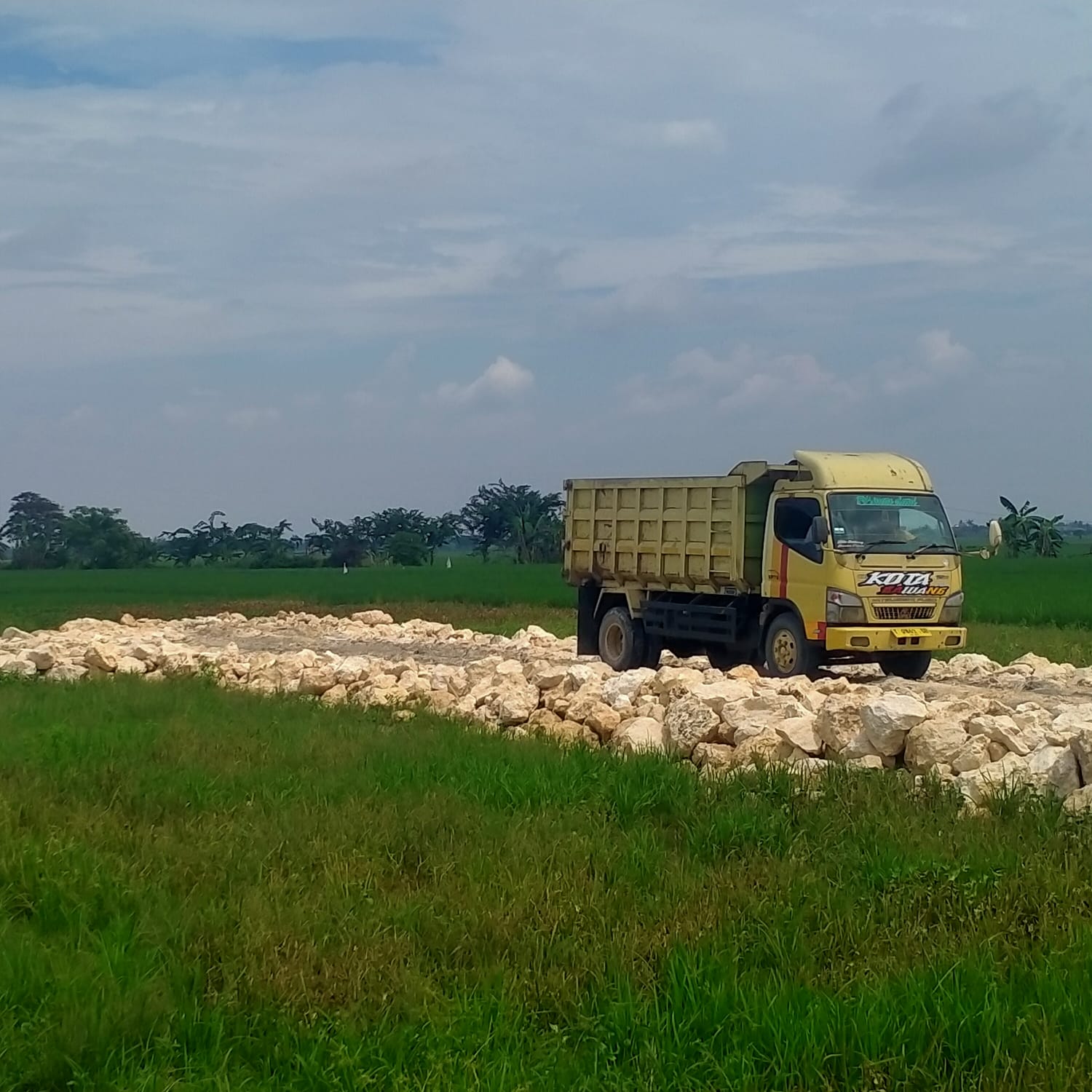 Caption : Sebuah truk pengangkut material terlihat berada di lokasi pembangunan kandang ayam di Dusun Bayur 1 RT 003 RW 008, Desa Payungsari, Kecamatan Pedes, Kabupaten Karawang. Aktivitas pembangunan sementara dihentikan guna melengkapi proses perizinan sesuai ketentuan yang berlaku.